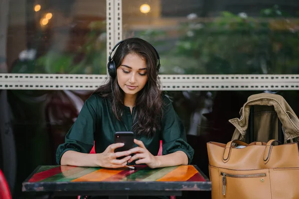年轻的印度亚洲女性喜欢音乐 她正在通过耳机传输到智能手机 — 图库照片