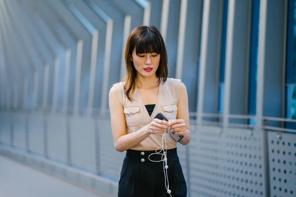 Chinese woman listening to music on her headphones