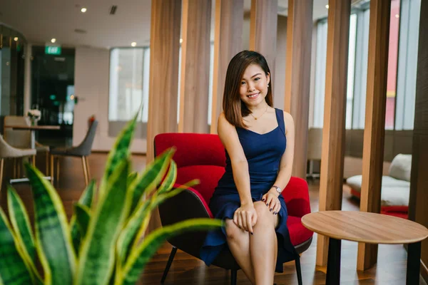 Uma Jovem Empresária Bonita Senta Uma Poltrona Vermelha Seu Escritório Fotografias De Stock Royalty-Free