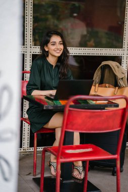 genç üniversite öğrencisi (Hint Asyalı kadın) eğitim ve gün boyunca dizüstü bilgisayar bir masa başında çalışma