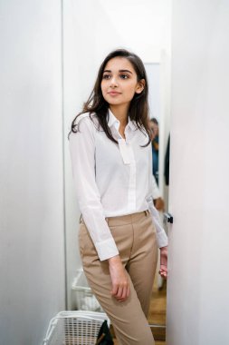 Yeni giyim moda salonu bir alışveriş merkezinde bir montaj odasında çalışıyor bir genç ve güzel Hint Asyalı kadın portresi.