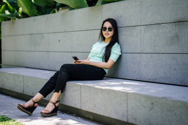 Genç, güzel Asyalı kadın parkta dinleniyor.