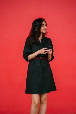 Bir güzel, Genç ve çekici Hint Asyalı kadın bir yeşil elbise ve kırmızı bir arka plan kırmızı kemer Studio portresi