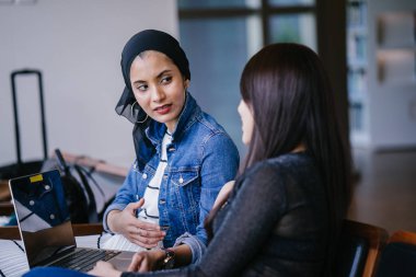 Müslüman bir Orta Doğulu kadın Çinli bir meslektaşıyla iş görüşmesi yapıyor..