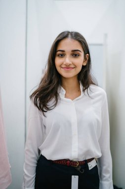 Trying dışarı giyim moda mağaza montaj odasında bir genç, uzun boylu, güzel ve zarif Hint Asyalı kadın portresi.