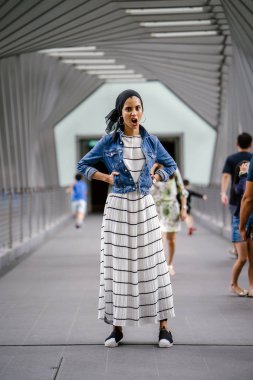 Gün boyunca güzel bir köprüde tek başına duran uzun boylu, genç, zarif ve çekici Malezyalı Müslüman bir kadının portresi..