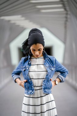 Gün boyunca güzel bir köprüde tek başına duran uzun boylu, genç, zarif ve çekici Malezyalı Müslüman bir kadının portresi..