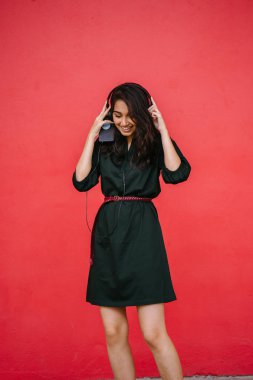 Bir güzel, Genç ve çekici Hint Asyalı kadın bir yeşil elbise ve kırmızı bir arka plan kırmızı kemer Studio portresi