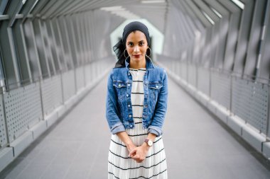 Gün boyunca güzel bir köprüde tek başına duran uzun boylu, genç, zarif ve çekici Malezyalı Müslüman bir kadının portresi..