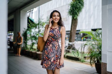 Ayakta ve gün boyunca onun smartphone bir şehirde Asya kentsel bir sokakta konuşurken Genç Hintli Asyalı kadın