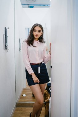 Yeni giyim moda salonu bir alışveriş merkezinde bir montaj odasında çalışıyor bir genç ve güzel Hint Asyalı kadın portresi.