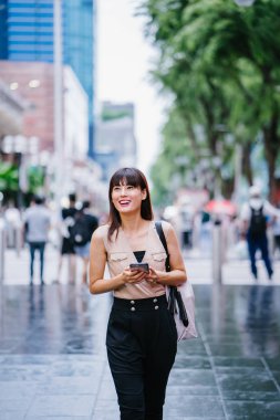 Onun smartphone kullanarak Genç, çekici Çinli Asyalı kadın