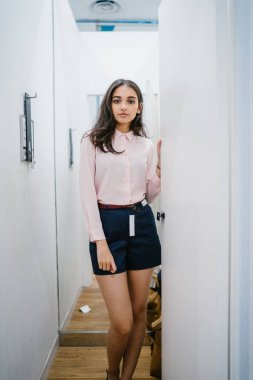 Yeni giyim moda salonu bir alışveriş merkezinde bir montaj odasında çalışıyor bir genç ve güzel Hint Asyalı kadın portresi.