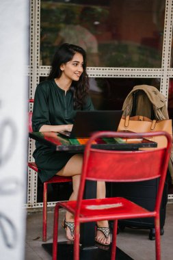 genç üniversite öğrencisi (Hint Asyalı kadın) eğitim ve gün boyunca dizüstü bilgisayar bir masa başında çalışma