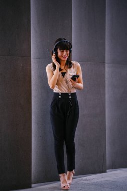 Onun kulaklık müzik dinlemek orta yaşlı, fotojenik bir Çinli kadın portresi