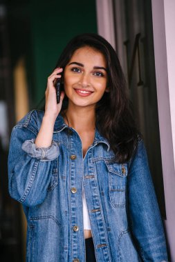 Onun Smartphone'da bahseden bir güzel, uzun boylu, zarif ve genç Hintli Asyalı kadın portresi. O bir retro Kot ceket giyiyor 