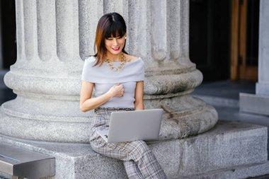 Modern dizüstü bilgisayar kullanarak çekici, kendine güvenen ve başarılı bir Çinli Asyalı kadının portresi