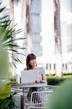 Modern dizüstü bilgisayar kullanarak çekici, kendine güvenen ve başarılı bir Çinli Asyalı kadının portresi