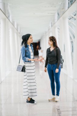 Gündüz vakti köprüde farklı etnik kökenlere sahip iki arkadaş. Biri Malezyalı Müslüman bir kadın, diğeri de Çinli bir Asyalı. İkisi de genç, enerjik ve çekici..