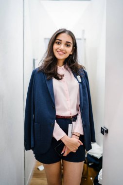 Yeni giyim moda salonu bir alışveriş merkezinde bir montaj odasında çalışıyor bir genç ve güzel Hint Asyalı kadın portresi.