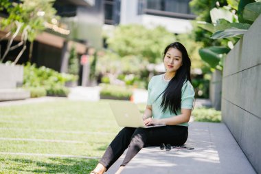 Genç ve çekici bir Asyalı kadın öğrenci oturur ve gün boyunca bir üniversite kampüsünde onu dizüstü bilgisayar üzerinde çalışır. O, o çalışırken gelişigüzel giyinmiş. 