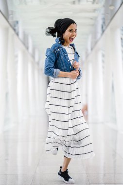 Güzel bir köprünün geçidinde duran uzun boylu, zarif ve ince bir Orta Doğulu kadının portresi (geometrik desenler)).