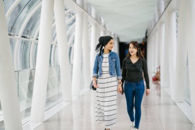 Gündüz vakti köprüde farklı etnik kökenlere sahip iki arkadaş. Biri Malezyalı Müslüman bir kadın, diğeri de Çinli bir Asyalı. İkisi de genç, enerjik ve çekici..