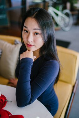 Bir açık havada açık havada oturan ve kırmızı bir çay seti çay sıcak bir fincan zevk genç, çekici, zarif ve güzel Asyalı kadın Portresi. 