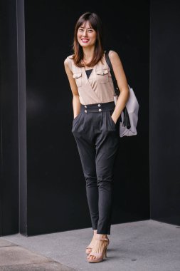 Bir çalışma hanım o pozlar ve onun baş shot siyah bir arka plan için gülümsüyor olarak stüdyo portresi