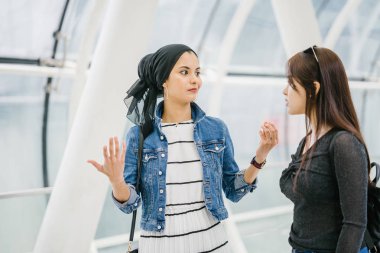 Gündüz vakti köprüde farklı etnik kökenlere sahip iki arkadaş. Biri Malezyalı Müslüman bir kadın, diğeri de Çinli bir Asyalı. İkisi de genç, enerjik ve çekici..