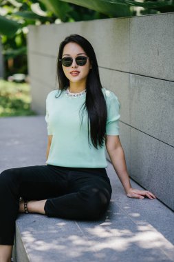 Gündüz vakti genç, seksi ve çekici bir Asyalı kadının portresi. O nane yeşili bir kazak giyiyor.