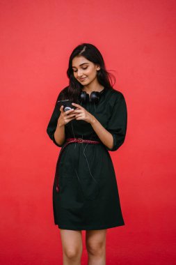 Bir güzel, Genç ve çekici Hint Asyalı kadın bir yeşil elbise ve kırmızı bir arka plan kırmızı kemer Studio portresi