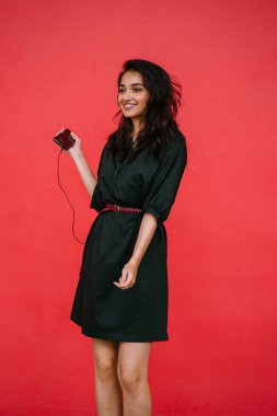 Bir güzel, Genç ve çekici Hint Asyalı kadın bir yeşil elbise ve kırmızı bir arka plan kırmızı kemer Studio portresi