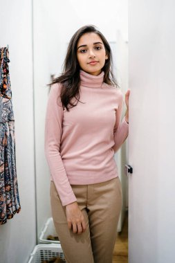 Yeni giyim moda salonu bir alışveriş merkezinde bir montaj odasında çalışıyor bir genç ve güzel Hint Asyalı kadın portresi.