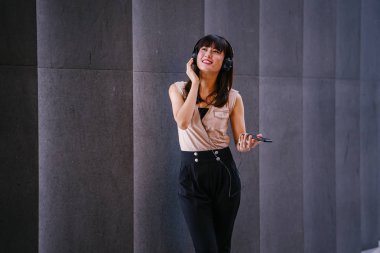 Onun kulaklık müzik dinlemek orta yaşlı, fotojenik bir Çinli kadın portresi