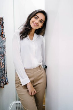 Yeni giyim moda salonu bir alışveriş merkezinde bir montaj odasında çalışıyor bir genç ve güzel Hint Asyalı kadın portresi.