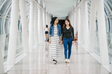 Gündüz vakti köprüde farklı etnik kökenlere sahip iki arkadaş. Biri Malezyalı Müslüman bir kadın, diğeri de Çinli bir Asyalı. İkisi de genç, enerjik ve çekici..