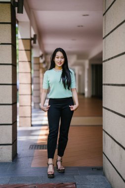 Gündüz vakti genç, seksi ve çekici bir Asyalı kadının portresi. O nane yeşili bir kazak giyiyor.