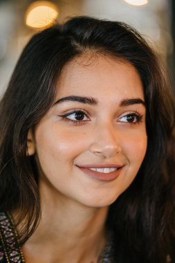 portre baş shot, kendine güvenen, Genç ve çekici Hint Asya kız sıcak aydınlatılmış bir trendy Cafe