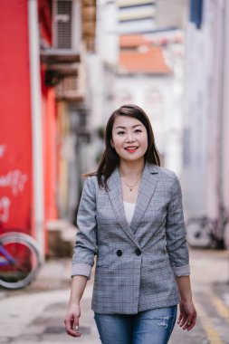 Genç güzel Asyalı kadın bir sokakta yürüyor