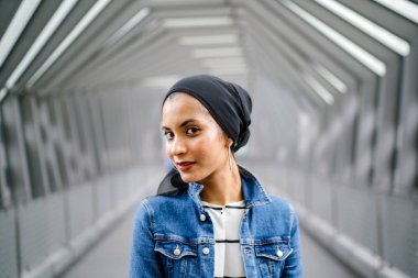 Genç, zarif ve çekici Malezyalı Müslüman kadın gün boyunca elbise ve kot ceket giyiyor..