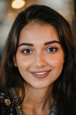 portre baş shot, kendine güvenen, Genç ve çekici Hint Asya kız sıcak aydınlatılmış bir trendy Cafe