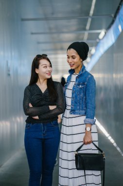 Gündüz vakti köprüde farklı etnik kökenlere sahip iki arkadaş. Biri Malezyalı Müslüman bir kadın, diğeri de Çinli bir Asyalı. İkisi de genç, enerjik ve çekici..