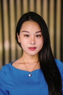 Kendinden emin, genç, güzel ve kendinden emin Asyalı bir kadının portresi.