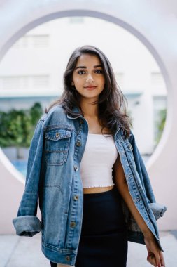 Bir güzel, genç ve çekici Hint Asyalı kadın beyaz bluz, mavi etek ve denim ceket portresi.