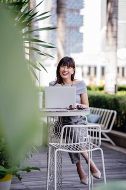 Modern dizüstü bilgisayar kullanarak çekici, kendine güvenen ve başarılı bir Çinli Asyalı kadının portresi