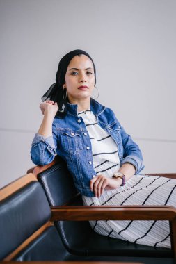 Genç, zarif ve çekici Malezyalı Müslüman kadın gün boyunca elbise ve kot ceket giyiyor..