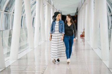 Gündüz vakti köprüde farklı etnik kökenlere sahip iki arkadaş. Biri Malezyalı Müslüman bir kadın, diğeri de Çinli bir Asyalı. İkisi de genç, enerjik ve çekici..