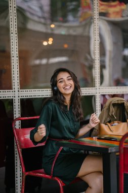 Genç Hintli Asyalı kadın o onun Smartphone-e doğru onun kulaklık streaming müzik hoşlanır