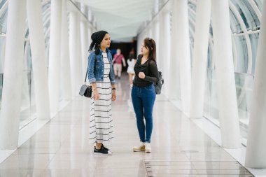 Gündüz vakti köprüde farklı etnik kökenlere sahip iki arkadaş. Biri Malezyalı Müslüman bir kadın, diğeri de Çinli bir Asyalı. İkisi de genç, enerjik ve çekici..